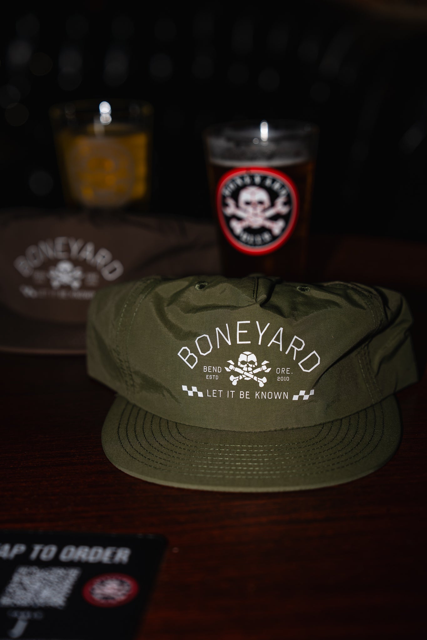 Green cap with 'Boneyard' logo on a dark background with candles and a sign.