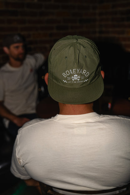 Person wearing a green cap with 'Boneyard' branding in an indoor setting.